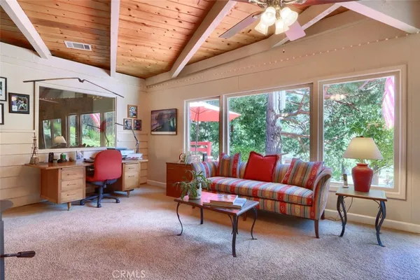 a living room with furniture a flat screen tv and windows