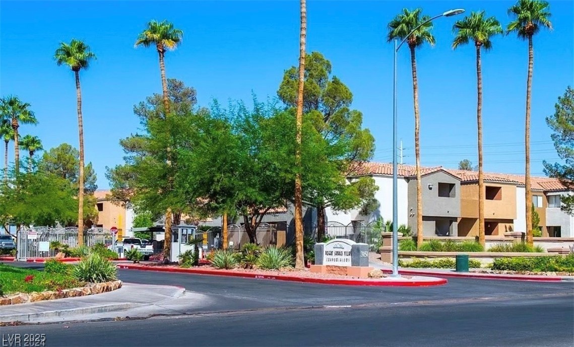 3151 North Soaring Gulls Drive, Unit 2211 Las Vegas, NV 89128 - Photo 12 of 20 View of asphalt road featuring curbs, a residential view, and street lights