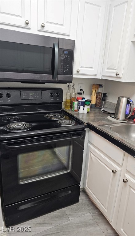 3151 North Soaring Gulls Drive, Unit 2211 Las Vegas, NV 89128 - Photo 6 of 20 Kitchen with black electric range, dark countertops, white cabinets, and stainless steel microwave