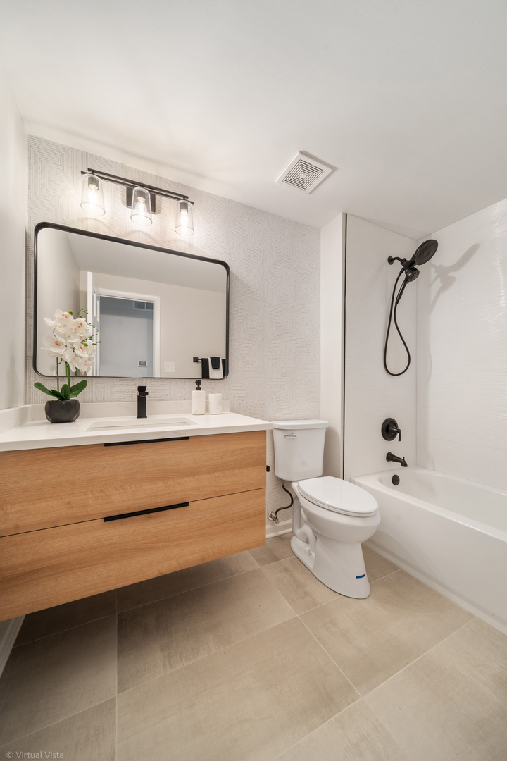 21-w040 Monticello Road Lombard, IL 60148 - Photo 18 of 33 a bathroom with a toilet a sink and mirror