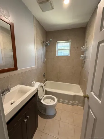 a bathroom with a sink a toilet a mirror and bathtub