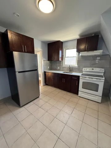 a kitchen with stainless steel appliances granite countertop a refrigerator sink and stove