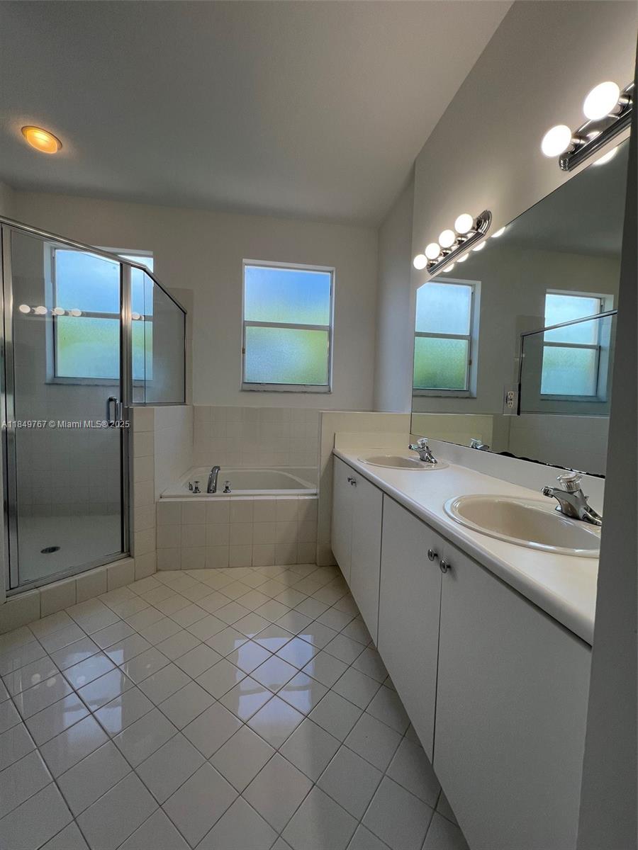 12724 Southwest 133rd Street Miami, FL 33186 - Photo 18 of 33 a bathroom with a tub sink shower and mirror