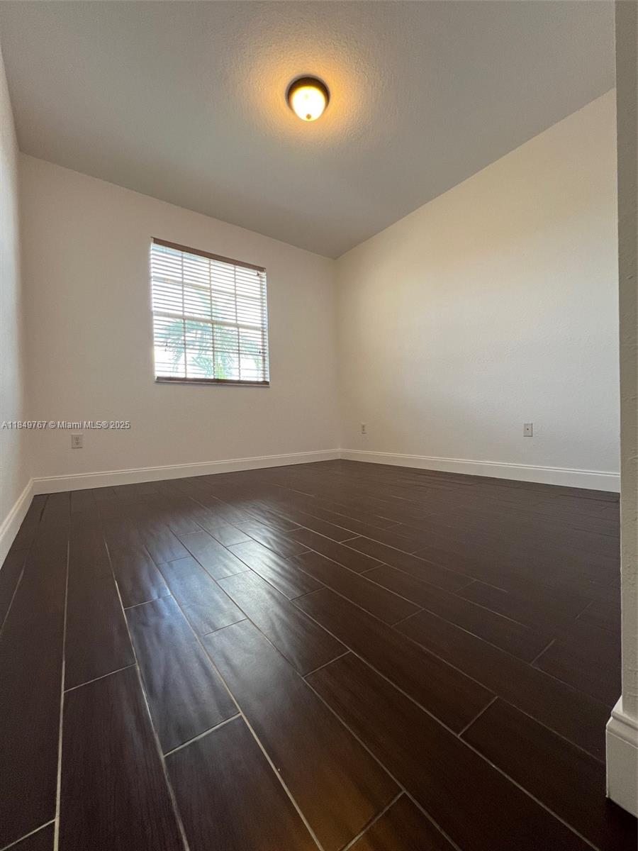 12724 Southwest 133rd Street Miami, FL 33186 - Photo 23 of 33 an empty room with wooden floor and windows