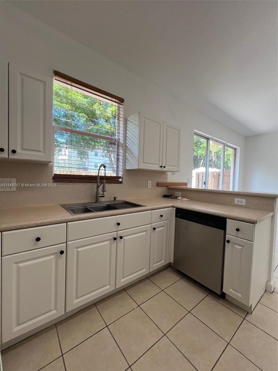 12724 Southwest 133rd Street Miami, FL 33186 - Photo 8 of 33 a kitchen with granite countertop white cabinets window a sink and appliances