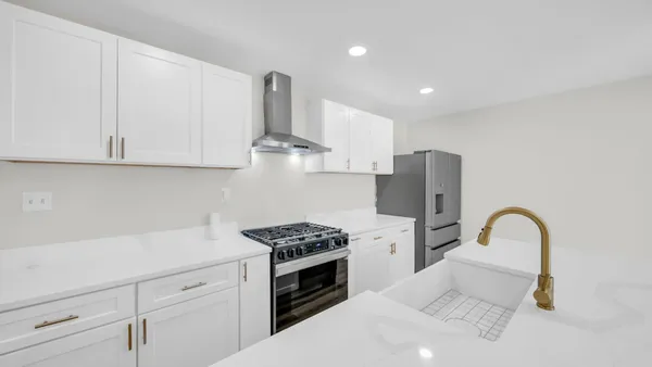 a kitchen with stainless steel appliances kitchen island a white stove top oven and cabinets