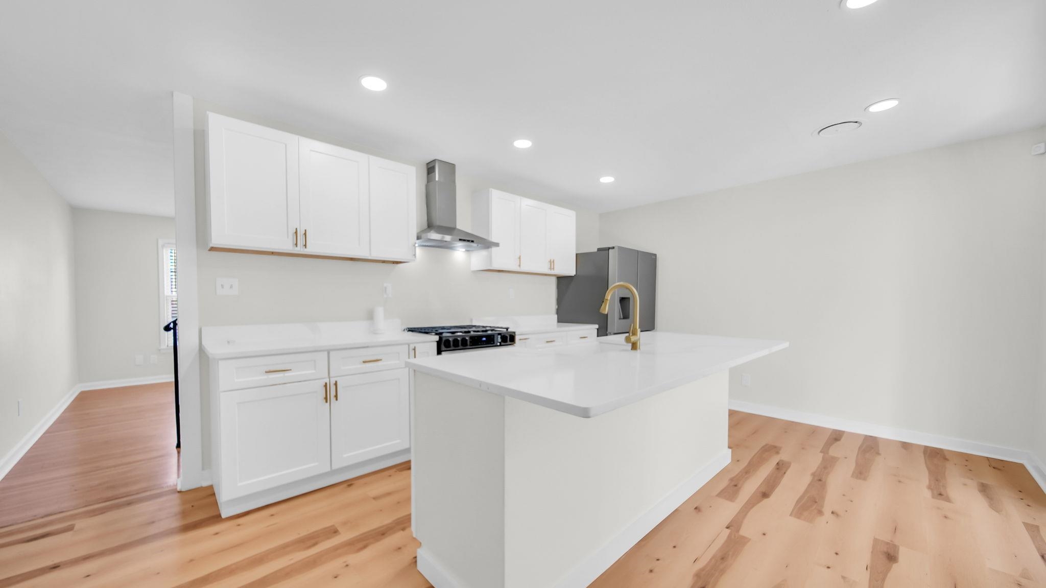 2800 Spring Hill Drive Memphis, TN 38127 - Photo 14 of 31 Kitchen with white cabinetry, wall chimney range hood, a center island with sink, stainless steel fridge with ice dispenser, and recessed lighting