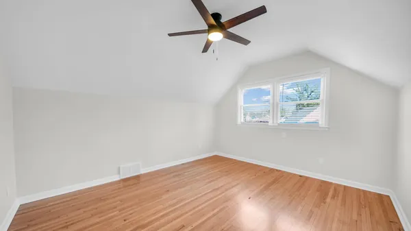 a view of empty room with wooden floor and window