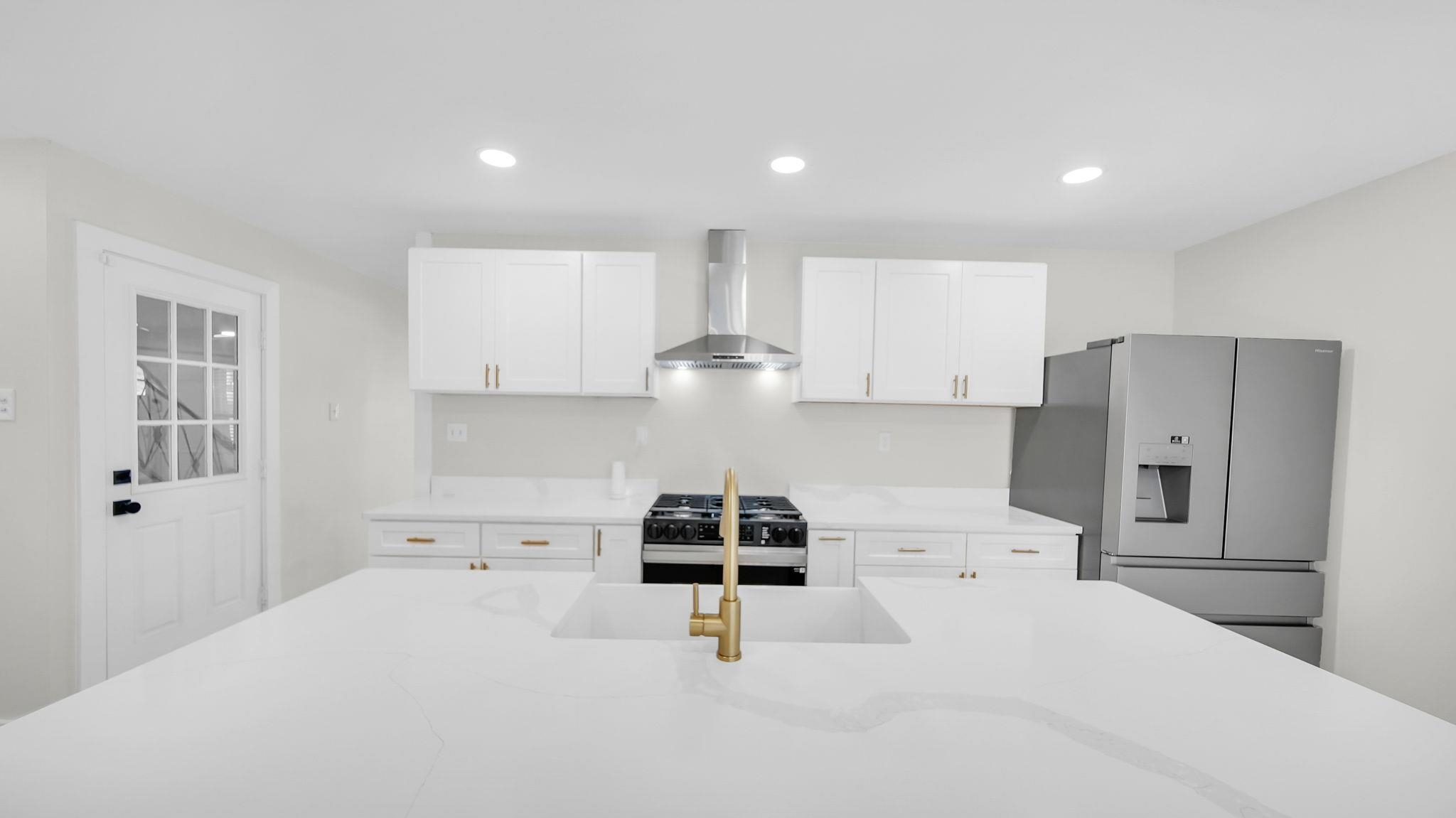 2800 Spring Hill Drive Memphis, TN 38127 - Photo 9 of 31 Kitchen featuring stainless steel fridge, recessed lighting, white cabinets, wall chimney range hood, and light stone counters