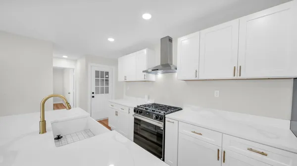 a kitchen with white cabinets and appliances