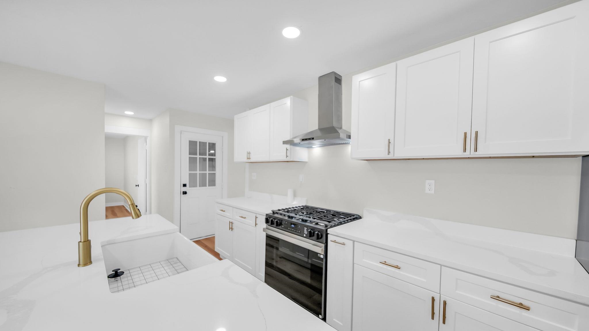 2800 Spring Hill Drive Memphis, TN 38127 - Photo 10 of 31 Kitchen featuring gas range oven, wall chimney exhaust hood, white cabinets, recessed lighting, and light stone countertops