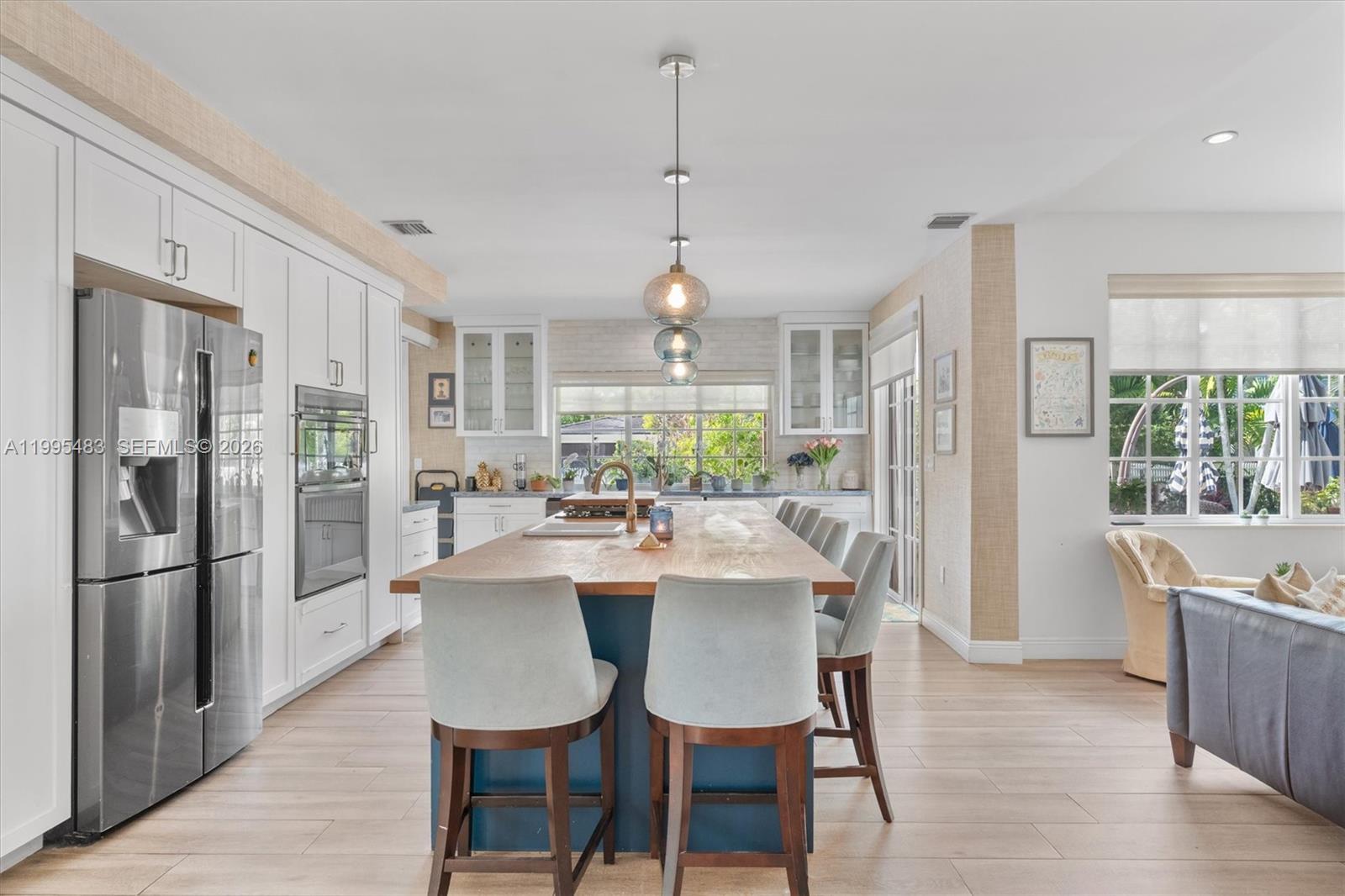 9636 Northeast 5th Avenue Road Miami Shores, FL 33138 - Photo 24 of 86 a view of a dining room and livingroom with furniture wooden floor a chandelier