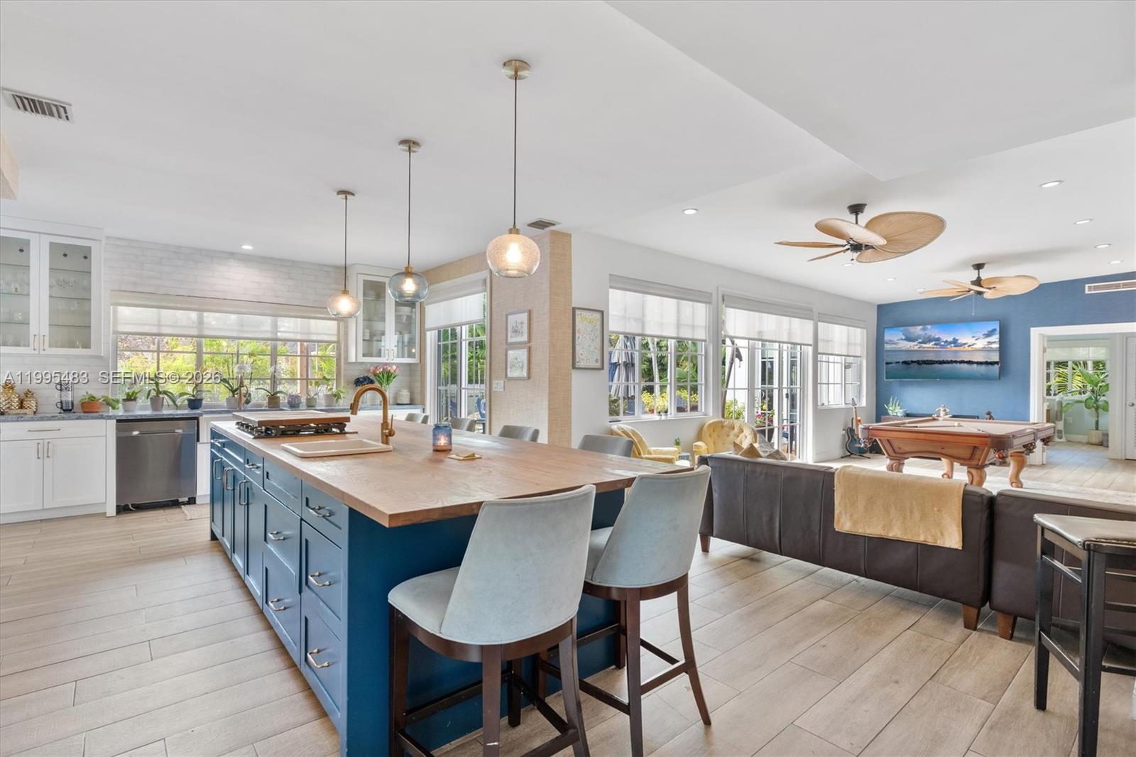 9636 Northeast 5th Avenue Road Miami Shores, FL 33138 - Photo 27 of 86 a large kitchen with kitchen island a sink a stove a dining table and chairs