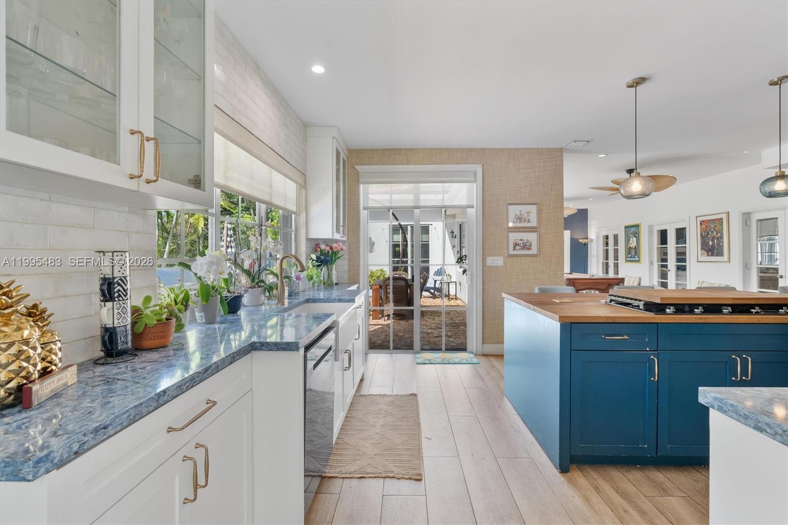 9636 Northeast 5th Avenue Road Miami Shores, FL 33138 - Photo 28 of 86 a view of a kitchen with kitchen island granite countertop wooden floor stainless steel appliances and a counter space