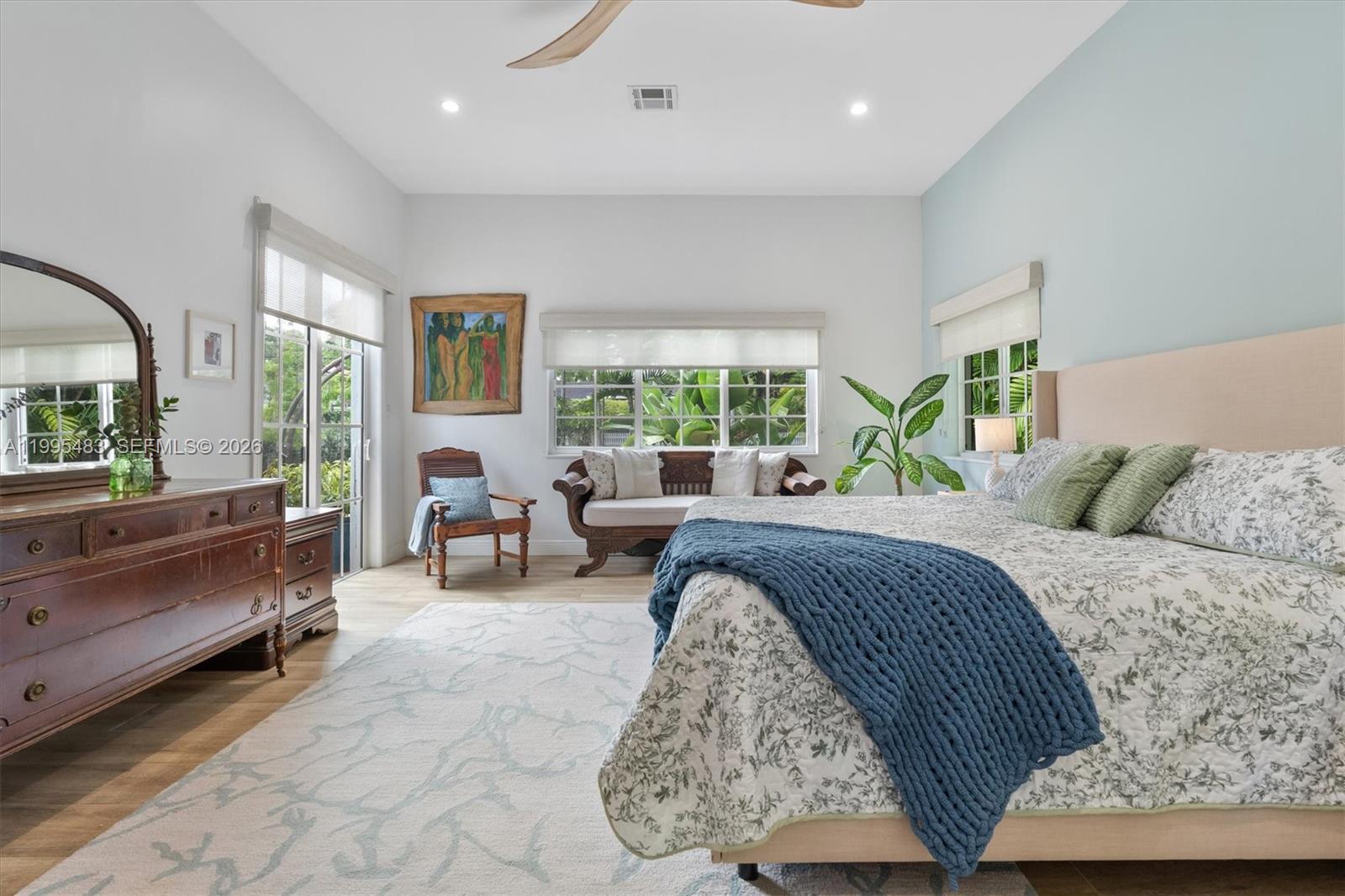 9636 Northeast 5th Avenue Road Miami Shores, FL 33138 - Photo 48 of 86 a spacious bedroom with a bed a table and large windows