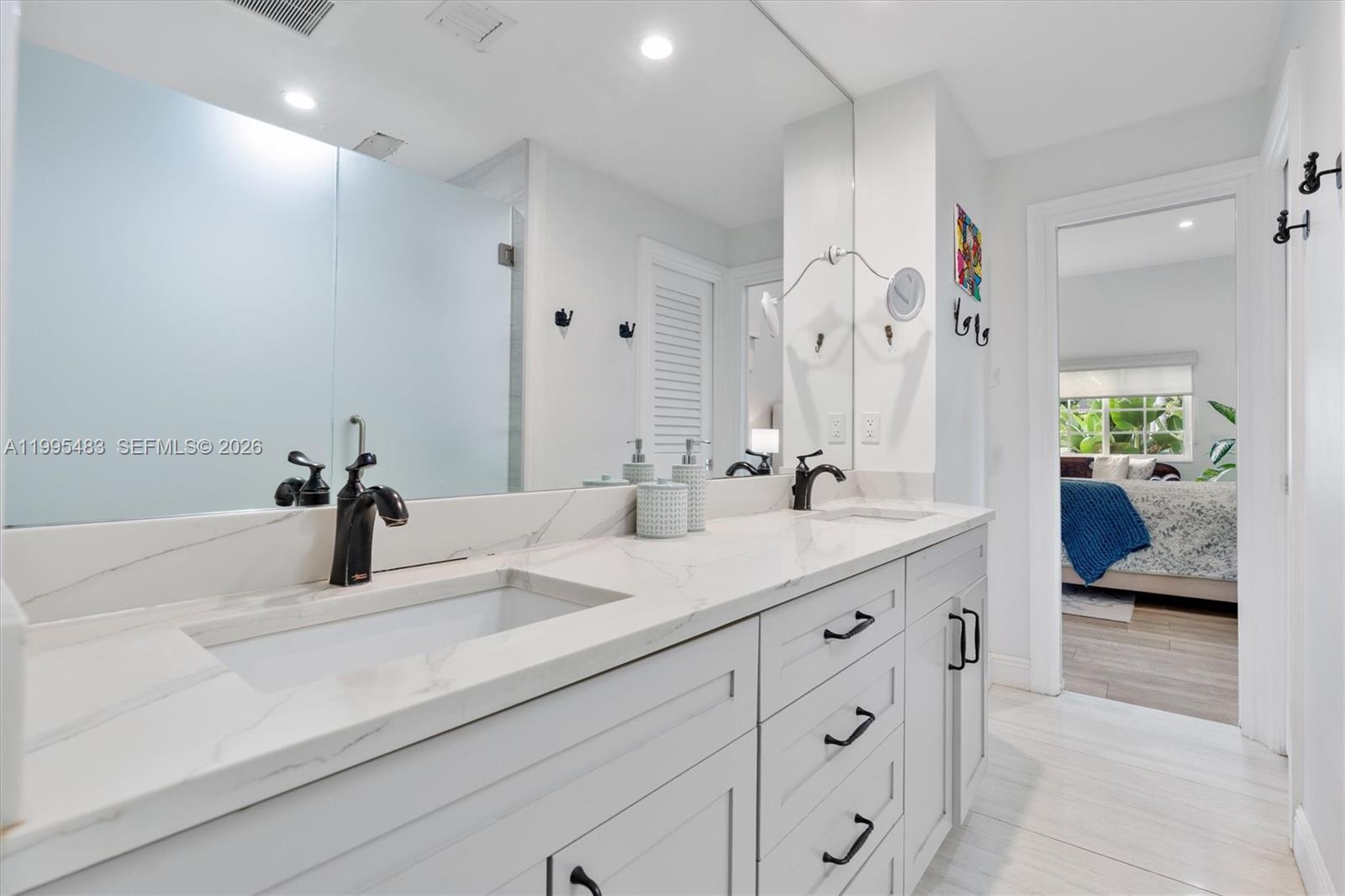 9636 Northeast 5th Avenue Road Miami Shores, FL 33138 - Photo 52 of 86 a bathroom with a sink double vanity and a mirror