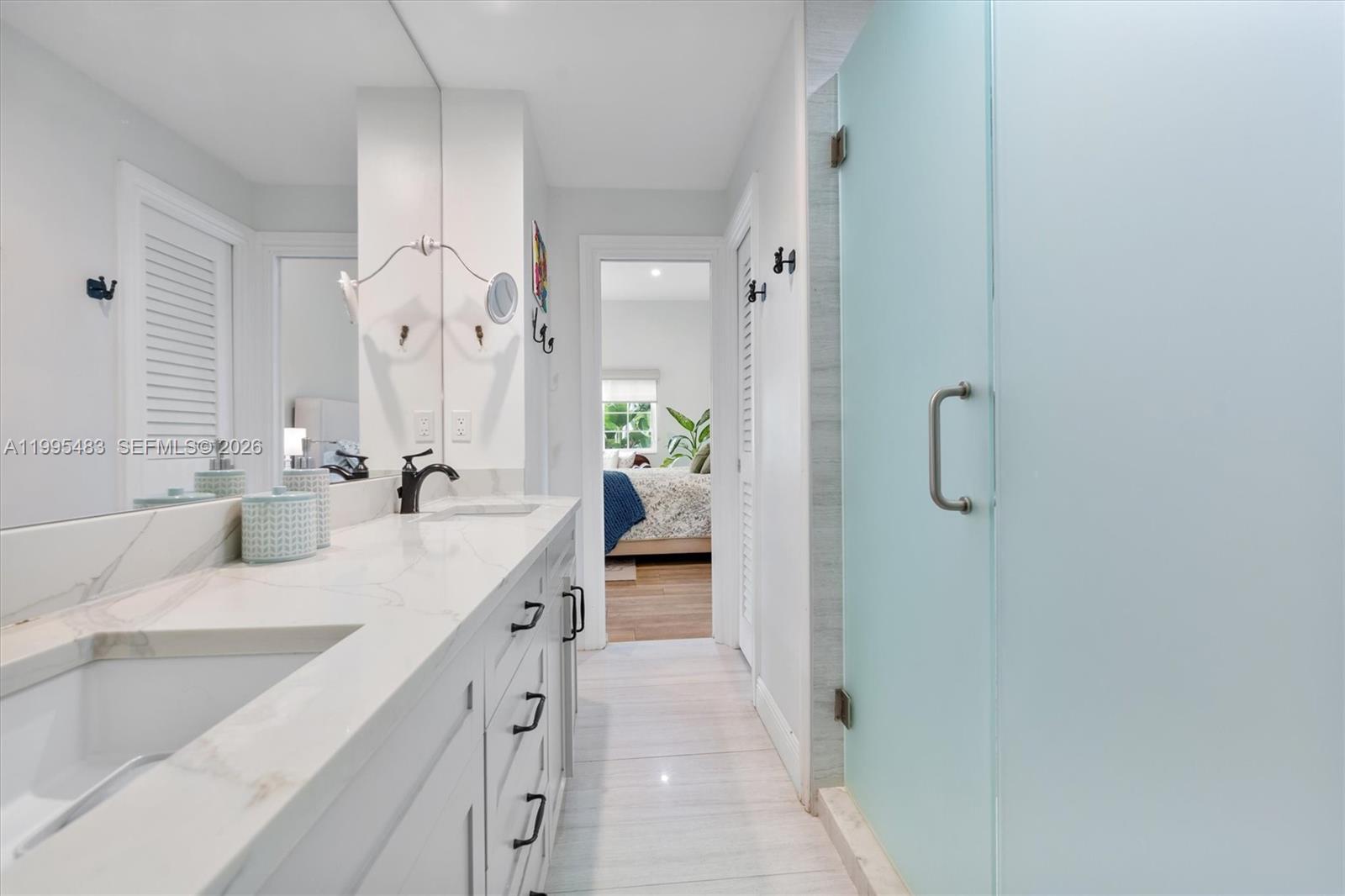 9636 Northeast 5th Avenue Road Miami Shores, FL 33138 - Photo 53 of 86 a spacious bathroom with a double vanity sink and a mirror
