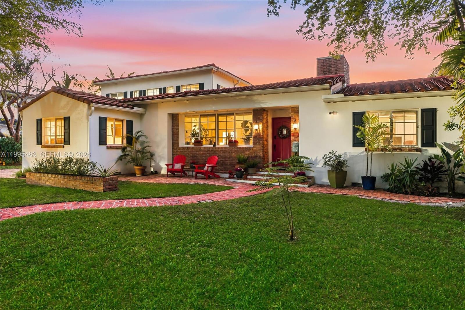 9636 Northeast 5th Avenue Road Miami Shores, FL 33138 - Photo 10 of 86 a front view of a house with a yard table and chairs