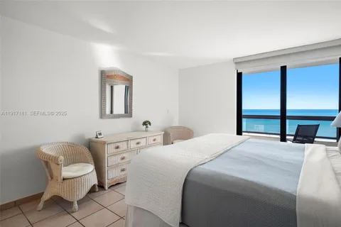 a bedroom with a bed a chair and a large mirror