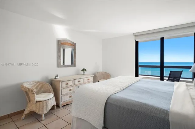 a bedroom with a bed a chair and a large mirror