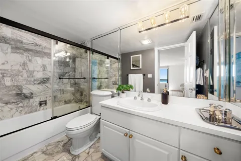 a bathroom with a double vanity sink toilet and shower
