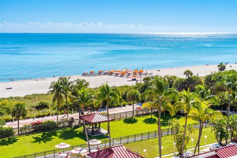 a view of an ocean with a floor to ceiling window and potted plants
