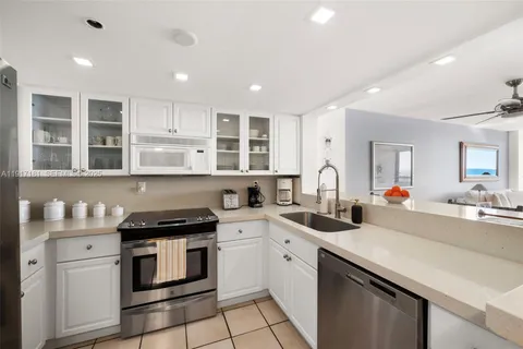 a kitchen that has a lot of cabinets in it and wooden floors