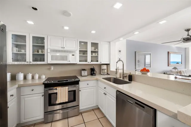 a kitchen that has a lot of cabinets in it and wooden floors
