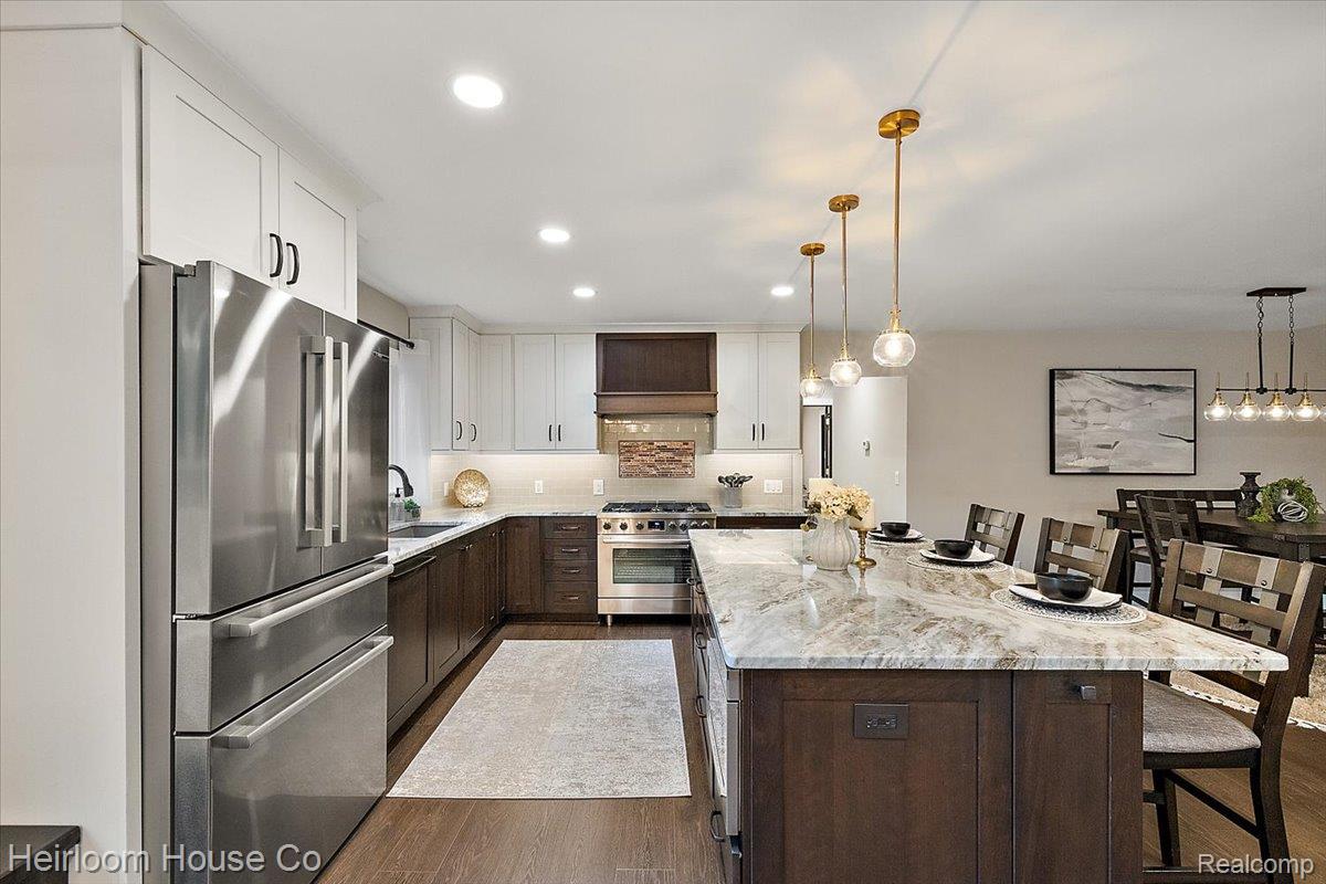 49001 Hanford Road Canton, MI 48187 - Photo 91 of 98 Gourmet kitchen featuring a large central island with seating, stainless steel appliances, two-tone cabinetry, recessed lighting, and wood-finish flooring