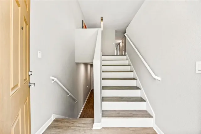 a kitchen with granite countertop white cabinets appliances and a window