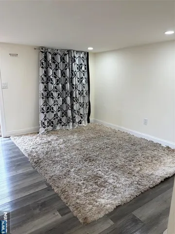 a view of a livingroom with wooden floor and bench in it