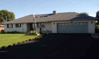 a front view of a house with yard and green space