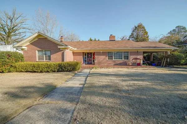 a front view of a house with a yard and potted plants