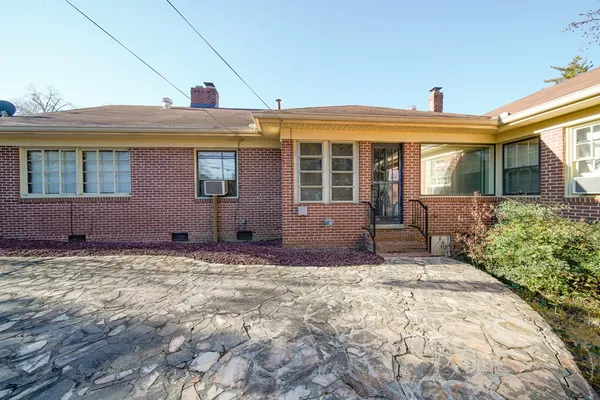 a front view of a house with a yard and potted plants