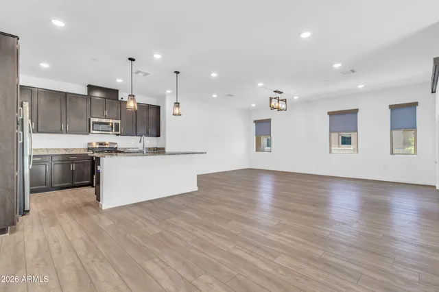 a large kitchen with stainless steel appliances kitchen island large trees and wooden floors