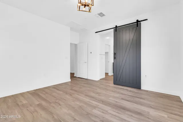 a view of an empty room with wooden floor