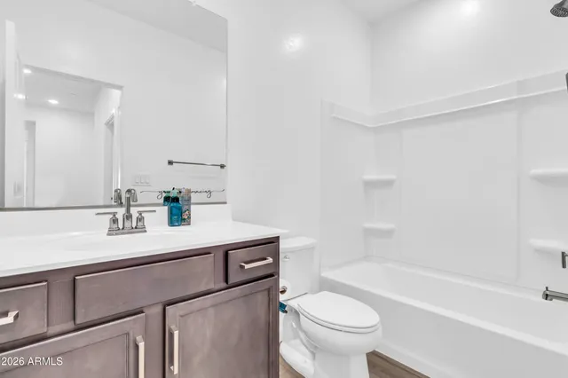 a bathroom with a sink a toilet a mirror a bathtub and shower