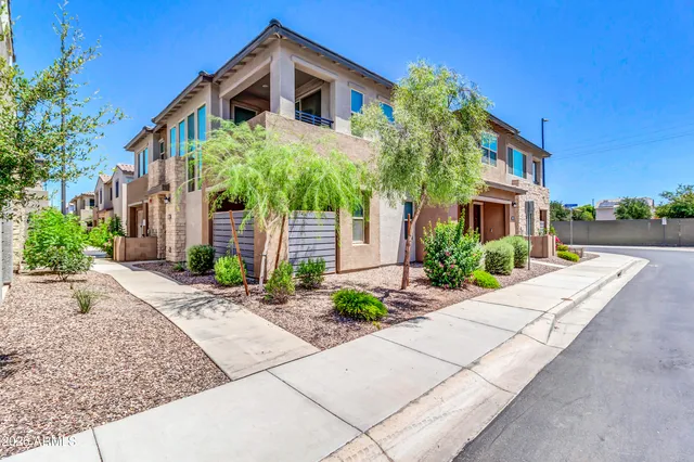 a front view of a house with a yard and potted plants