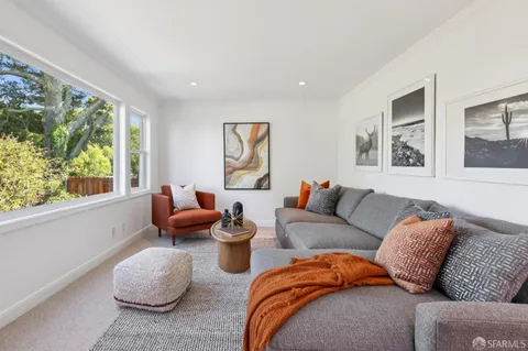 a living room with furniture and a floor to ceiling window