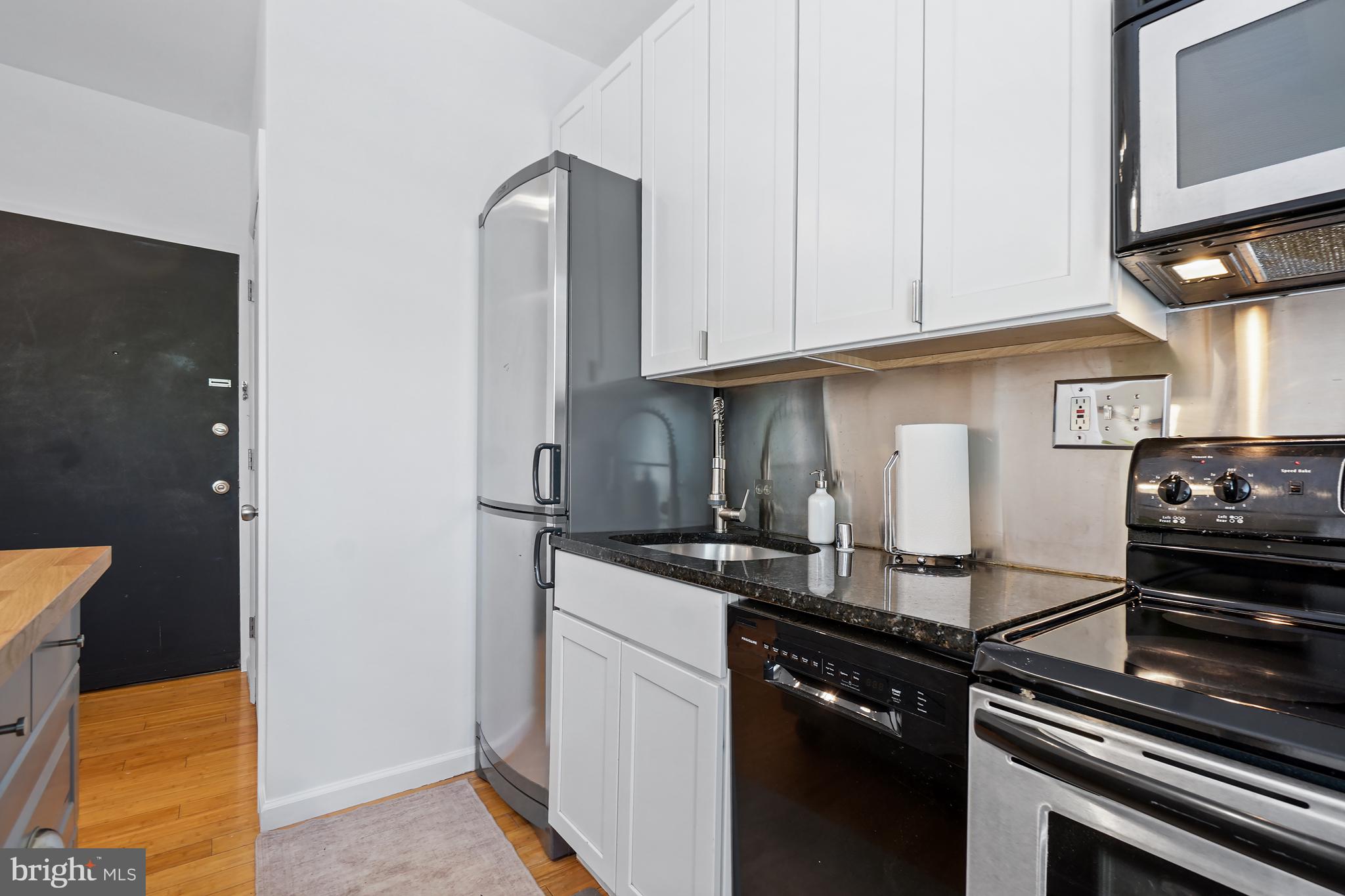 1822 15th Street Northwest, Unit 303 Washington, DC 20009 - Photo 7 of 22 a kitchen with a sink and a stove top oven