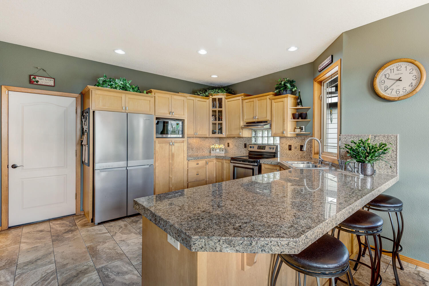 2434 Southwest 34th Drive Redmond, OR 97756 - Photo 12 of 36 a kitchen with kitchen island granite countertop stainless steel appliances a refrigerator a stove a sink and a center island