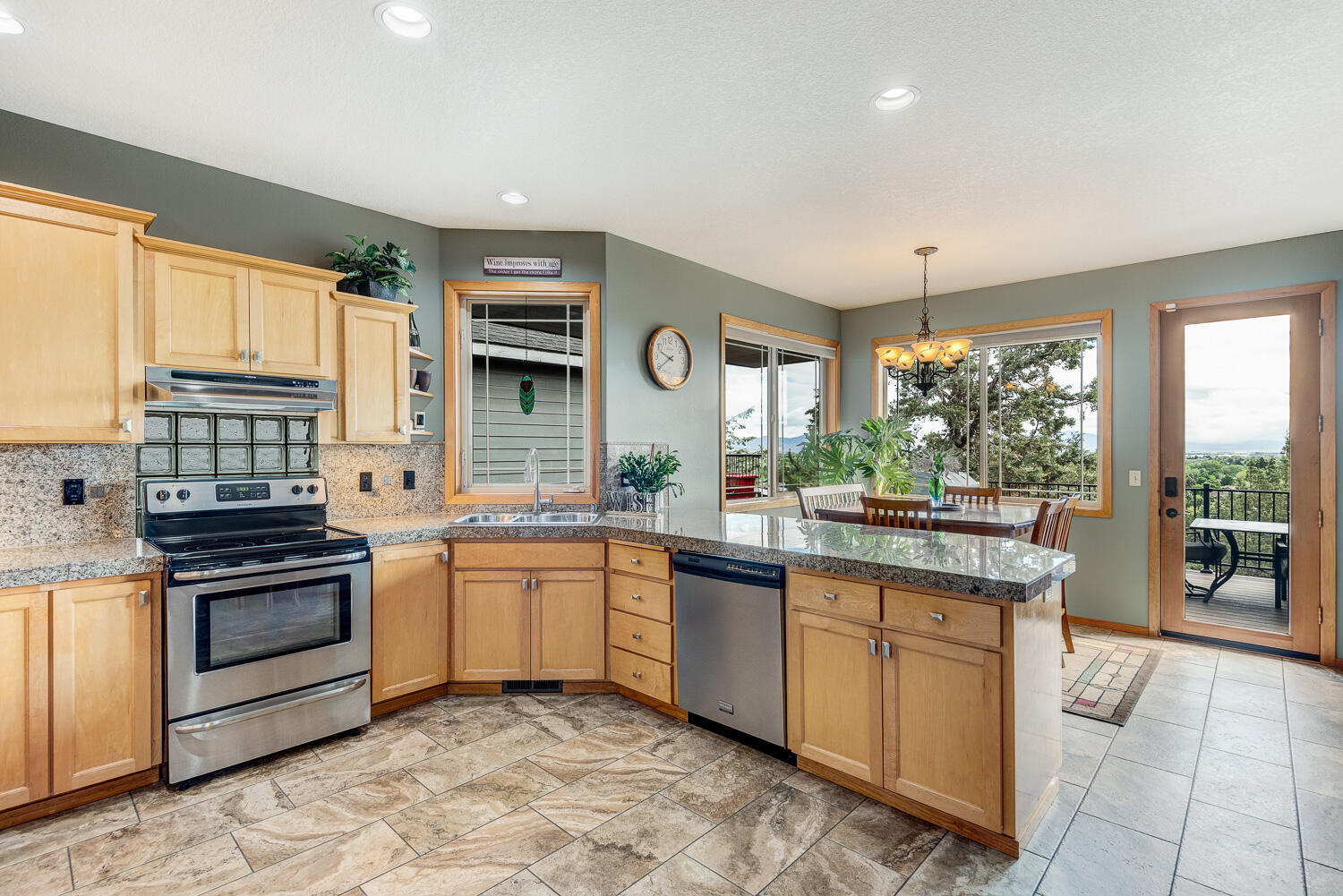 2434 Southwest 34th Drive Redmond, OR 97756 - Photo 13 of 36 a kitchen with stainless steel appliances granite countertop a stove a sink and a refrigerator
