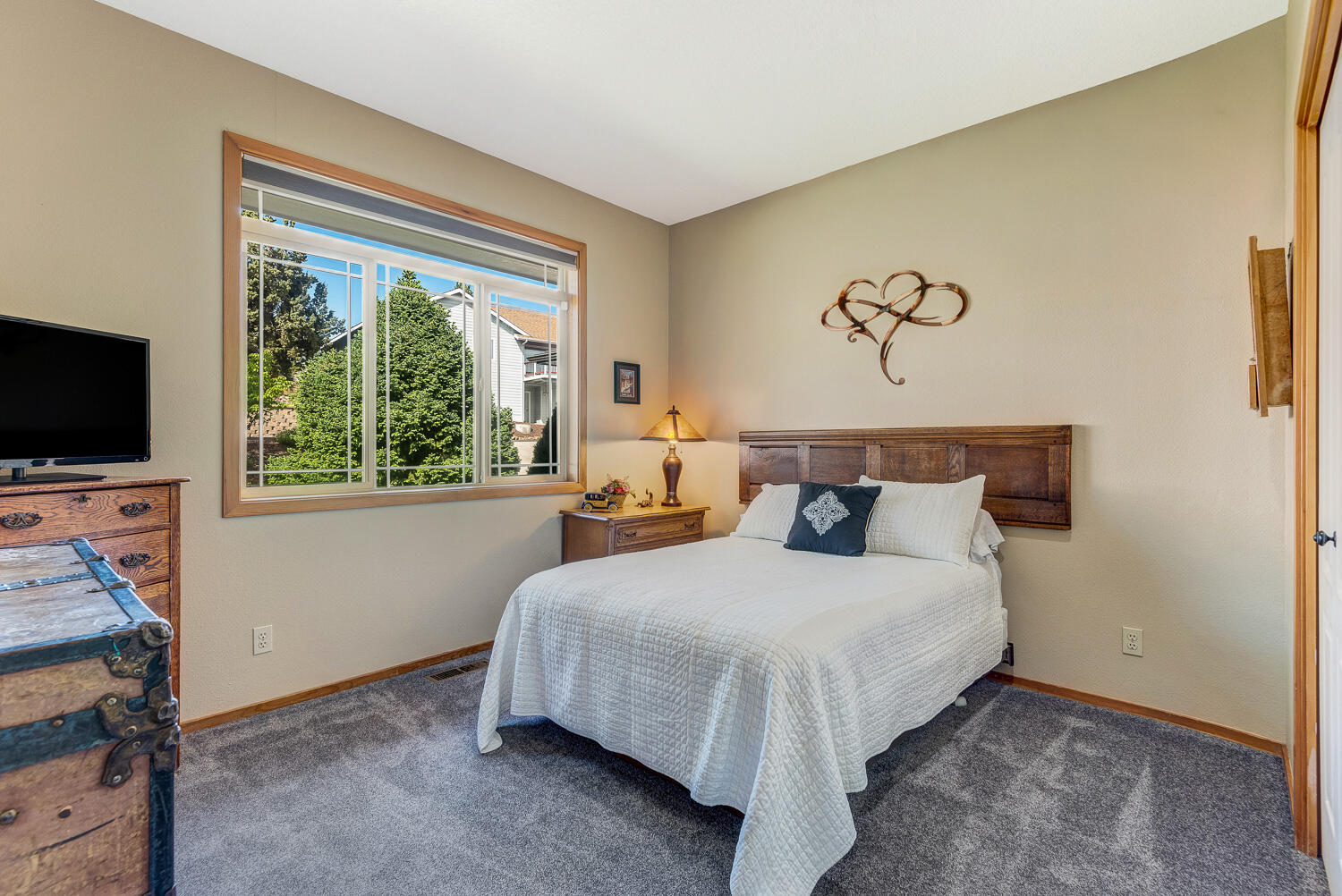2434 Southwest 34th Drive Redmond, OR 97756 - Photo 23 of 36 a bedroom with a bed and a flat tv screen on the dresser