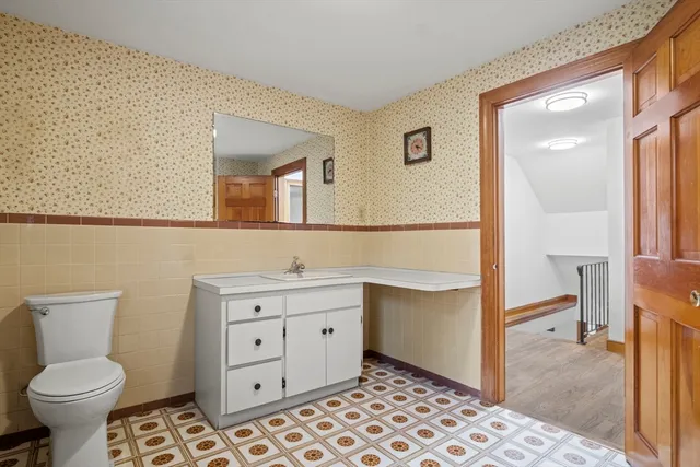 a bathroom with a toilet sink and mirror