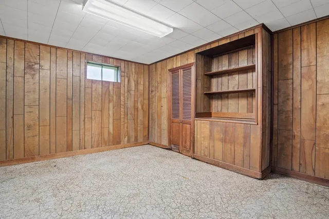 a view of empty room with cabinet and stairs