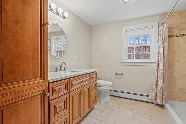 a bathroom with a granite countertop toilet and sink