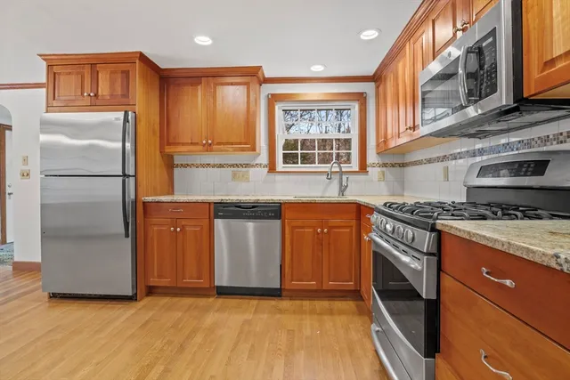 a kitchen with granite countertop a sink stove and refrigerator
