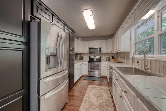 a kitchen with white cabinets and stainless steel appliances