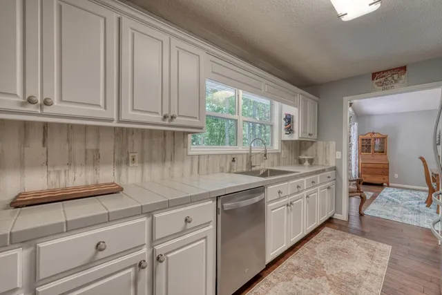 a kitchen with granite countertop white cabinets and white appliances