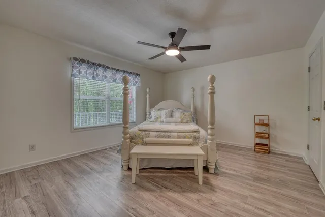 a view of a livingroom with wooden floor and a ceiling fan